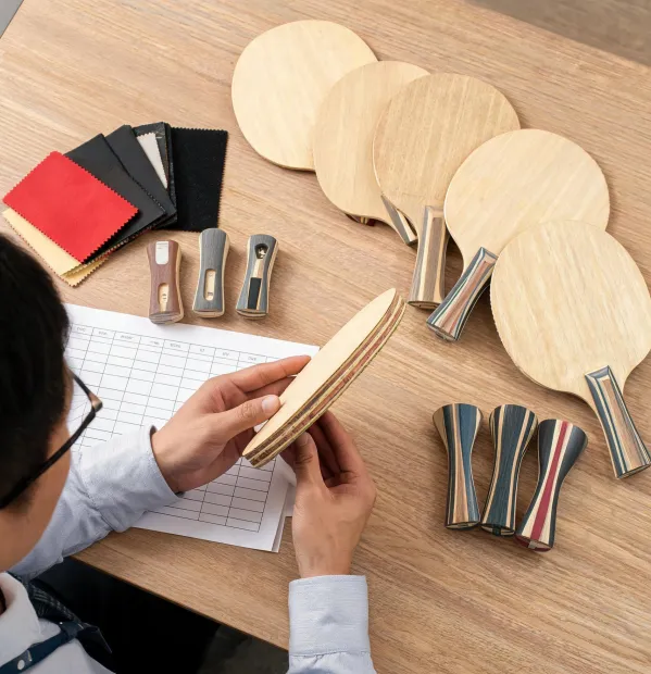 Procurement specialist comparing table tennis paddle construction notes